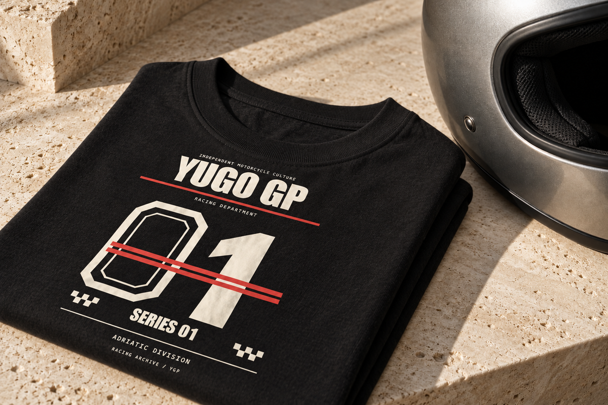 Yugo GP Racing Department 01 graphic tee and a silver helmet on warm stone